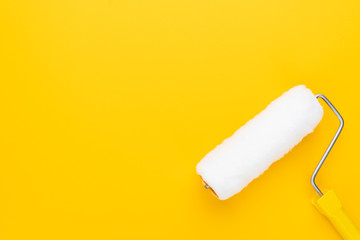 clean paint roller on the yellow background with copy space