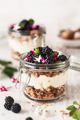 Petit Déjeuner Sain avec des Granola ou Muesli, des Mûres, yaourt à la Noix de Coco et Fleurs Comestibles