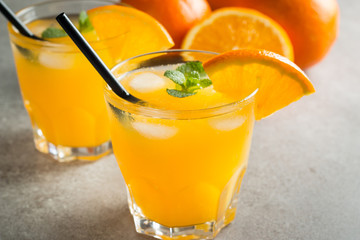Photo of fresh orange juice in the glass jar. Summer healthy organic drink concept. Cold beverages with ice and orange fruits.