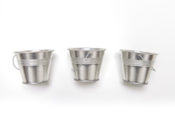 Three small empty metal bucket on white background.