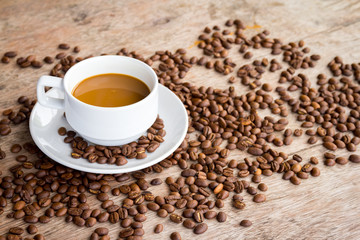 Coffee cup and coffee beans on wooden table