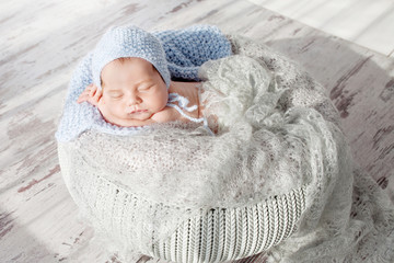 Sweet newborn baby sleeps.  Newborn boy folded handles  in a basket © fadzeyeva