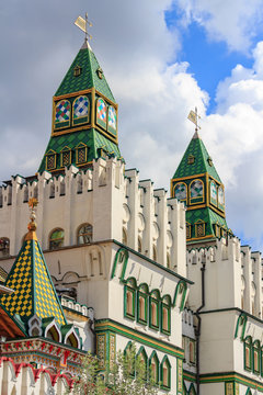 Watchtowers above main entrance to the territory of Izmailovo Kremlin on a background of cloudy blue sky in Moscow