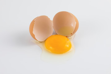 Egg yolk with broken egg shell on white background