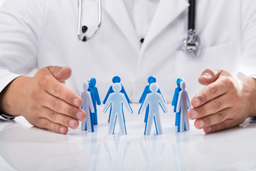 Doctor's hand protecting human figures