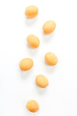 Yellow apricots on white background. Flat lay, top view.