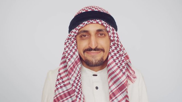 A man with a beard and national clothes smiles and enjoys the deal. An Arab in a modern office. The field of business and trade.