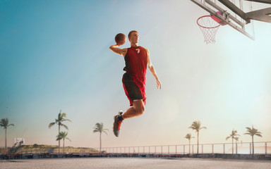 Streetball. Basketball player in action on sunset.