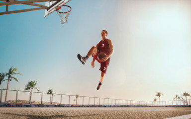Streetball. Basketball player in action on sunset.