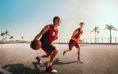 Streetball. Basketball player in action on sunset.