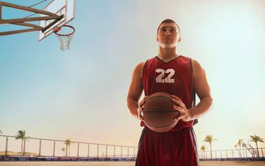 Streetball. Basketball player in action on sunset.