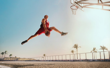 Streetball. Basketball player in action on sunset. - obrazy, fototapety, plakaty