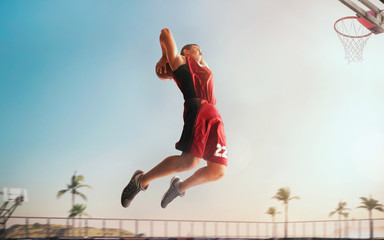 Streetball. Basketball player in action on sunset.