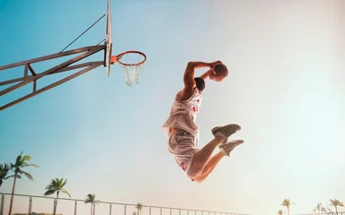 Muurstickers Streetball. Basketball player in action on sunset. © VIAR PRO studio