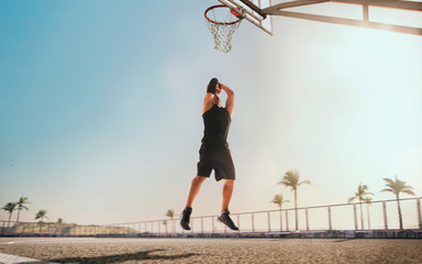 Streetball. Basketball player in action on sunset.