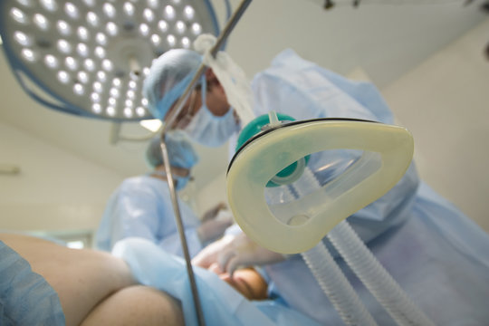 Mask for an narcosis close-up in foreground of surgery