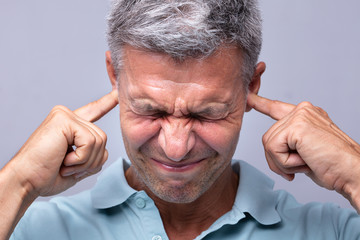 Man Covering His Ears With Fingers