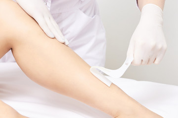 Waxing woman leg. Sugar hair removal. laser service epilation. Salon wax beautician procedure