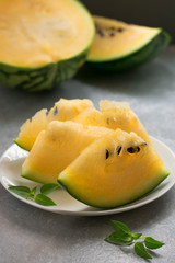Slices of a yellow watermelon on a white plate