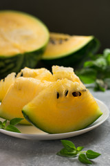 Slices of a yellow watermelon on a white plate