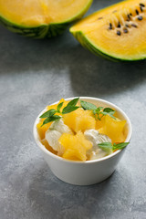 Yellow watermelon slices and ice cream, decorated with green leaves.