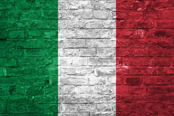 Flag of Italy over an old brick wall background, surface