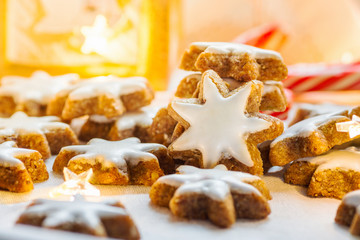 Stack Pile of Traditional German Christmas Cookies Home Baked Glazed Cinnamon Stars. Sparkling Garland Lights Candle Candy Canes Festive Magic Atmosphere. Holiday Greeting Card