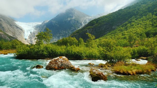 Briksdal glacier with a mountain river in the foreground. The amazing nature of Norway