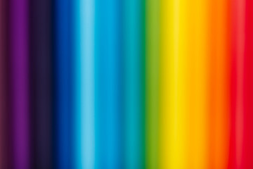 Blurred Color pencils in a row on yellow background.