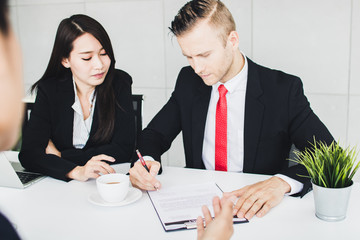 Business people reading clearly before signing on contract in meeting