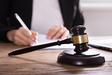 Close-up Of Gavel On Wooden Desk