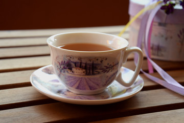Fototapeta premium Tea on the terrace, white teacup with purple motive
