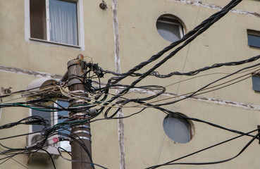 Overcrowded Pole With Wires On A Sovietic Building Background