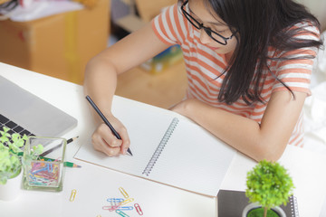 Asian adorable girl be happy and smiling use laptop computer to work at home.Girl sitdown at living room.working online lifestyle