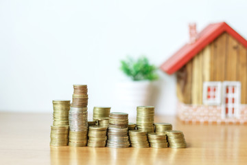 Real estate or property investment concept. coin stack with house model on table.