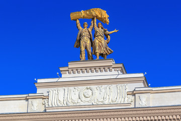 Sculptural composition Tractor driver and collective farm girl on top of arch of Main entrance on Exhibition of Achievements of National Economy (VDNH) in Moscow