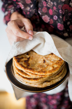 Woman holding Traditional Indian bread - Aloo paratha or aalu parotha, potato stuffed bread