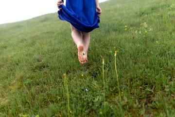 Cropped view of beautiful young woman walking in forest barefoot