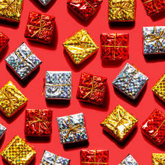 赤バックの上にゴールドとシルバーと赤のプレゼントギフトボックスを散りばめて置く
