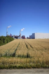 Fototapeta na wymiar Landschaft mit rauchender Fabrik im Hintergrund