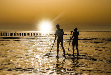 couple en paddle au coucher du soleil