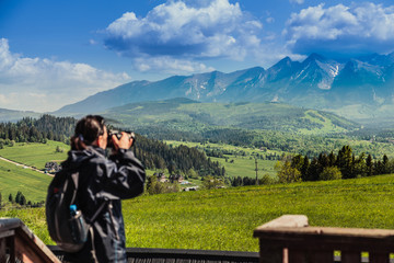 Tourist in the mountains photographing beautiful views. Focus on the landscape.
