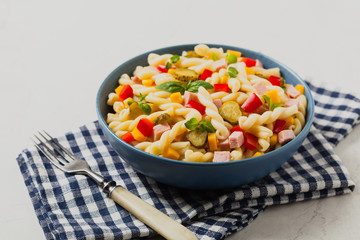 Italian fusilli pasta in a salad with ham and vegetables.