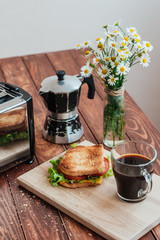 Toaster, Turkish for coffee, flowers on a wooden table. Baked toast with a salad and a marker on a wooden board.