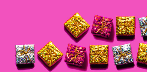ピンクックにゴールドとシルバーと赤のギフトボックスを並べて置く