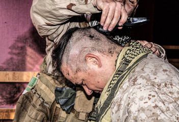 Soldier cuts comrades hair with trimmer. United States marine shaving friends head with clipper in...