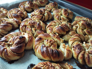 Homemade Swedish cardamom and cumin rolls on a oven tray.