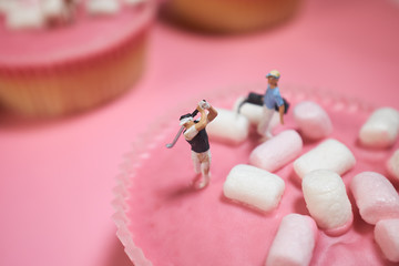 Miniature golfer on pink cake