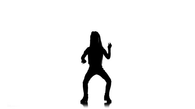 Baby raises her leg up in studio. White background. Silhouette. Slow motion