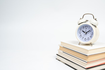 Alarm clock and books isolated on white background.